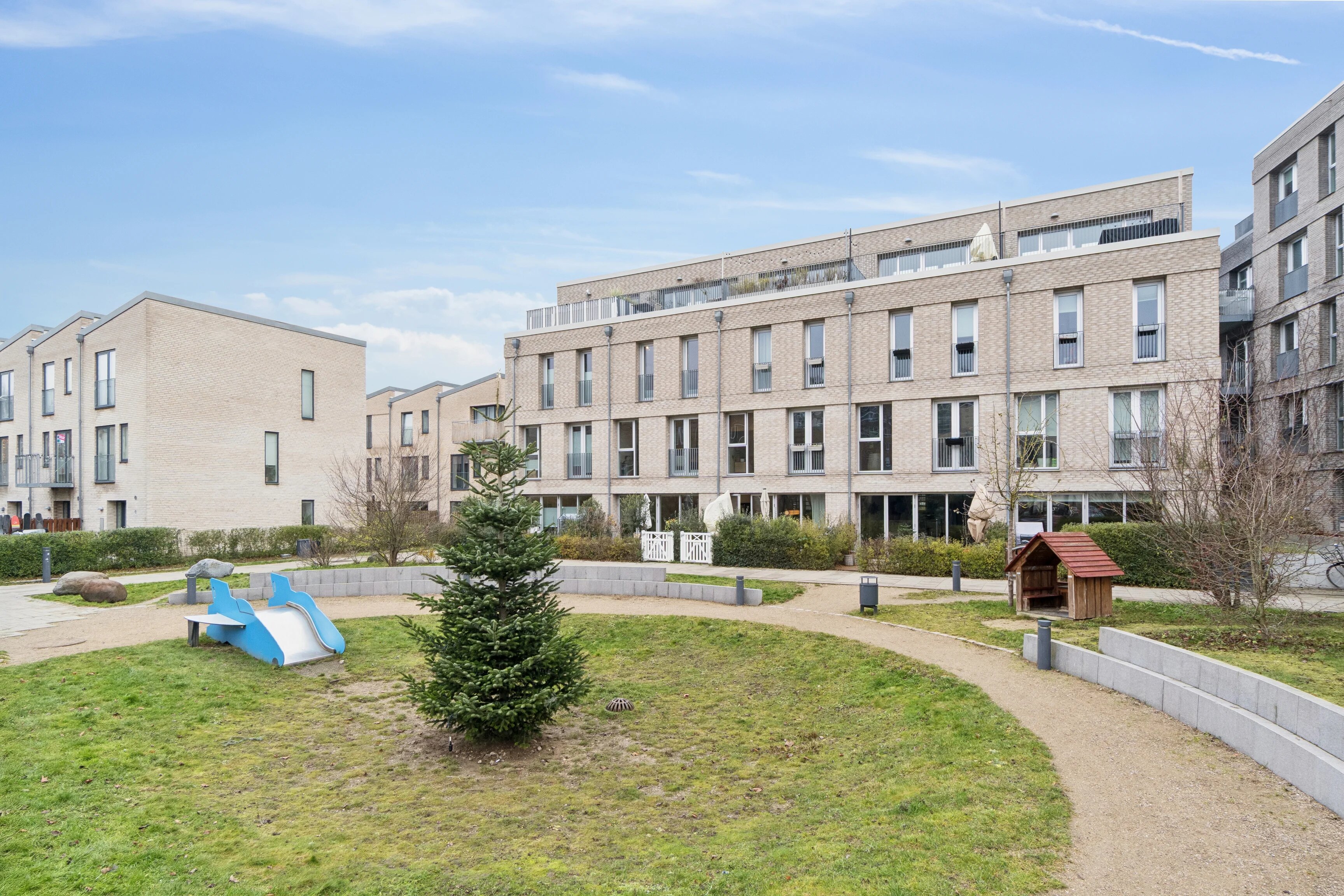 Fælles gårdmiljø med legeplads og grønne arealer